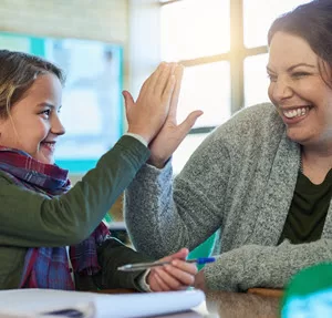 Female coach child high five - SQUARE 300px Learn the brain science behind a learning mindset